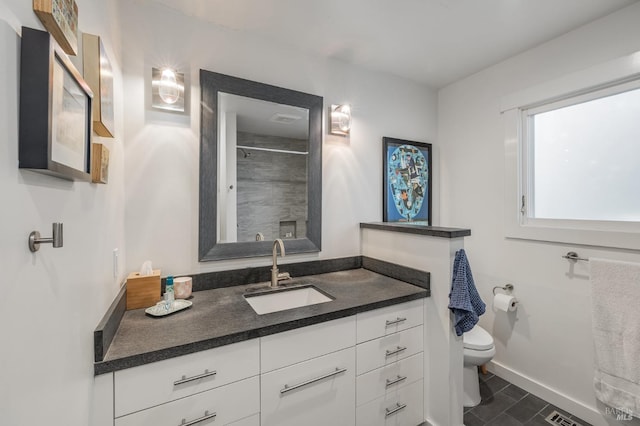 bathroom with a shower, vanity, and toilet