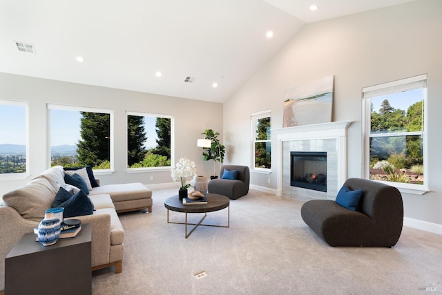 living room with light carpet, a fireplace, and high vaulted ceiling