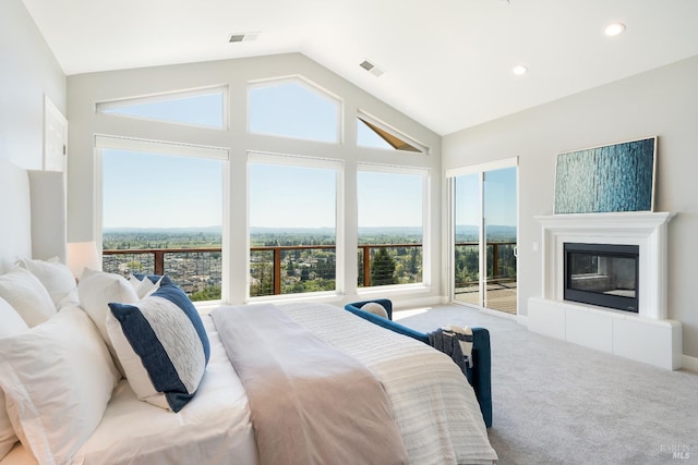 carpeted bedroom featuring access to exterior, lofted ceiling, and a tile fireplace