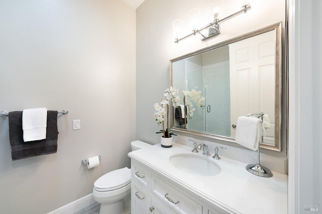 bathroom featuring vanity, toilet, and a shower with shower door