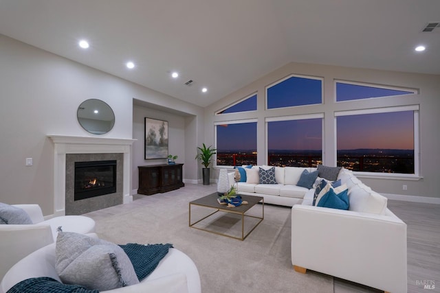 living room with vaulted ceiling and a tiled fireplace