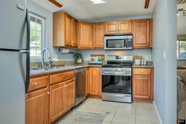 kitchen featuring sink, light tile patterned flooring, vaulted ceiling, and appliances with stainless steel finishes