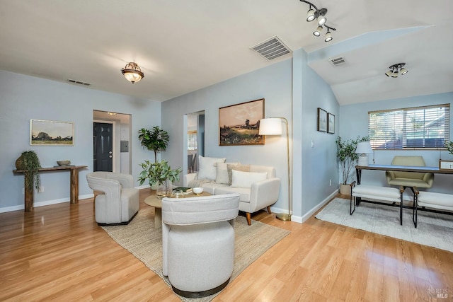 living room featuring vaulted ceiling and light hardwood / wood-style flooring