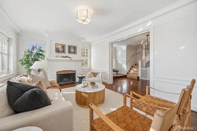 living room with dark hardwood / wood-style floors, ornamental molding, and a chandelier