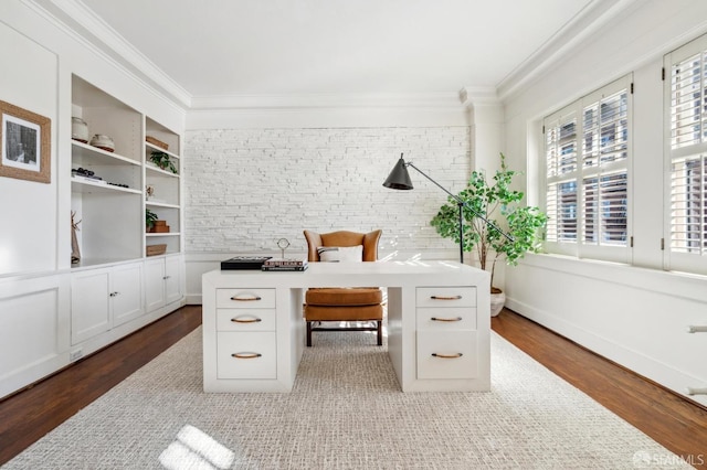 office area featuring wood-type flooring, built in features, and crown molding