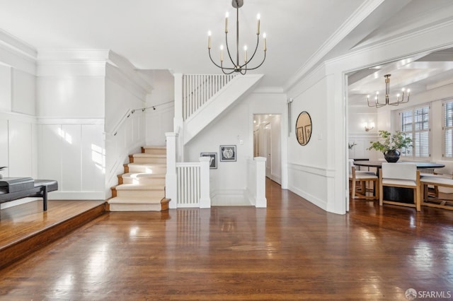 entryway featuring crown molding, dark wood-type flooring, and an inviting chandelier