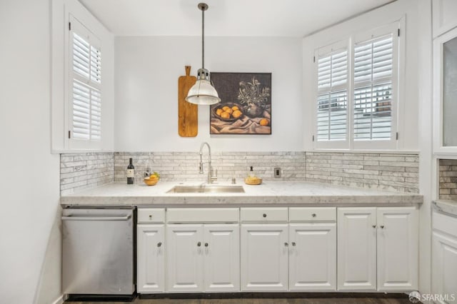 kitchen with tasteful backsplash, dishwasher, sink, decorative light fixtures, and white cabinets