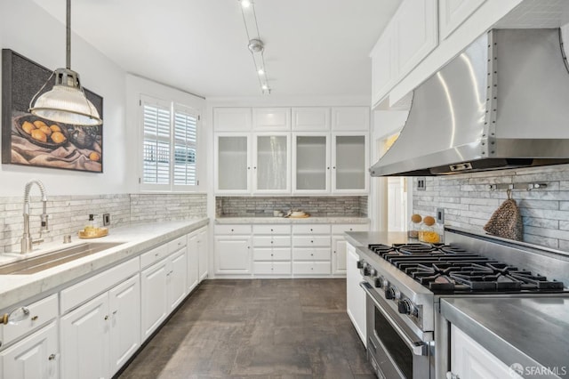 kitchen featuring hanging light fixtures, sink, white cabinetry, high end stainless steel range oven, and ventilation hood