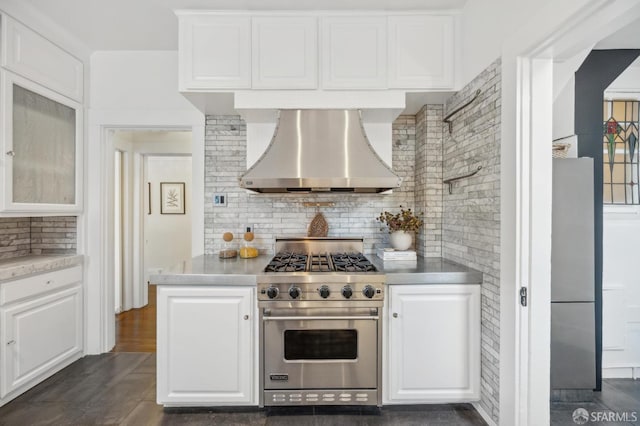 kitchen featuring wall chimney exhaust hood, backsplash, white cabinetry, dark hardwood / wood-style floors, and stainless steel appliances