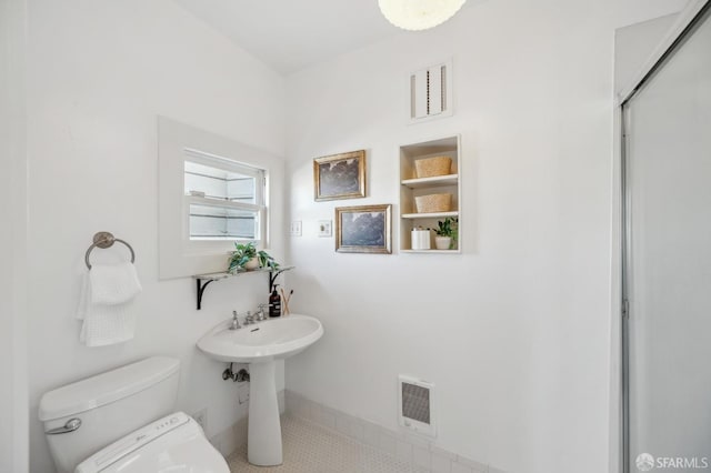 bathroom featuring built in features, toilet, and tile patterned floors