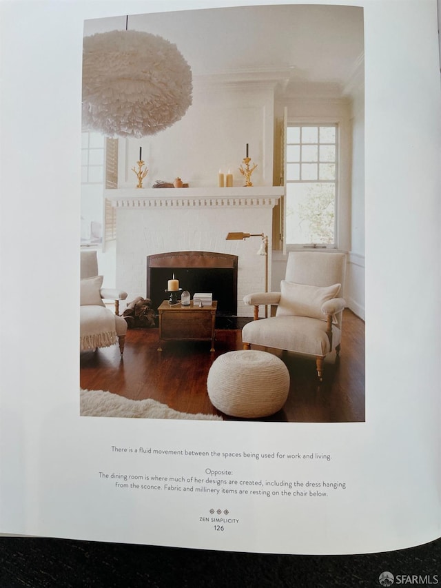 sitting room with hardwood / wood-style flooring and ornamental molding