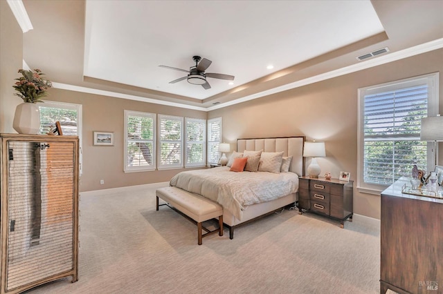 bedroom with light carpet, ceiling fan, crown molding, and a raised ceiling