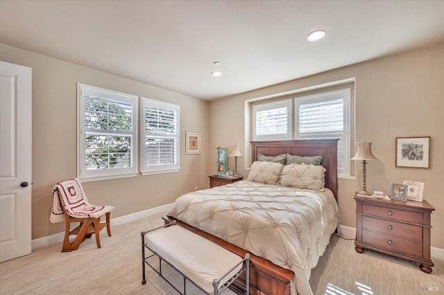 bedroom featuring multiple windows and light carpet