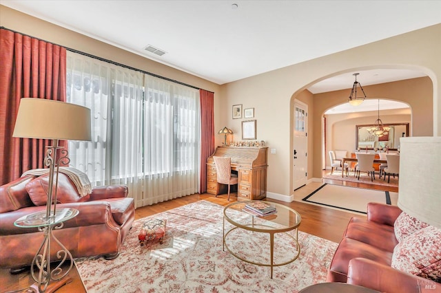 living room featuring light hardwood / wood-style flooring and an inviting chandelier