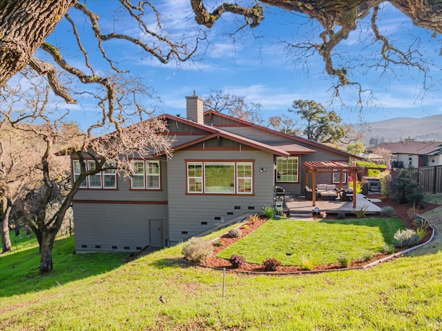 rear view of property featuring a lawn, a pergola, and a deck with mountain view