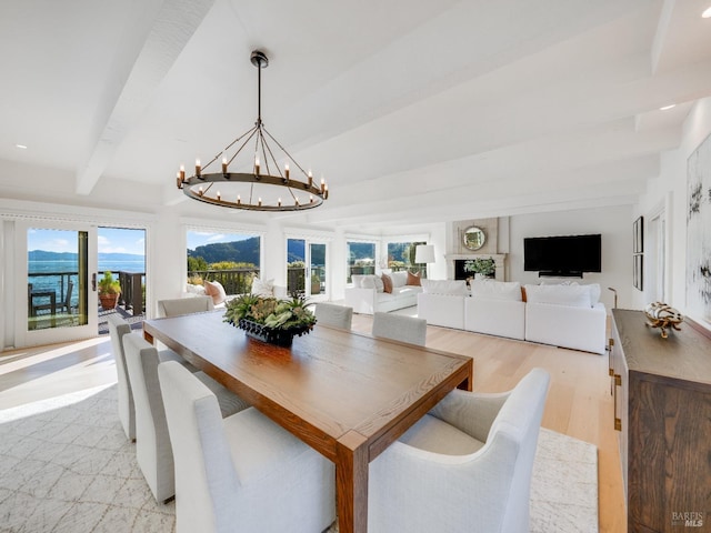 dining room featuring beamed ceiling, light hardwood / wood-style floors, and a chandelier