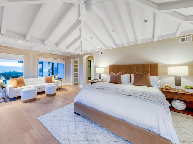 bedroom featuring vaulted ceiling with beams and wood-type flooring