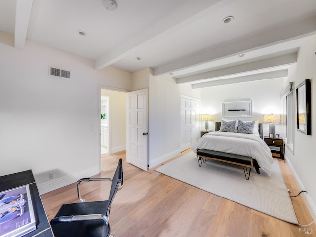 bedroom featuring beam ceiling and light hardwood / wood-style flooring