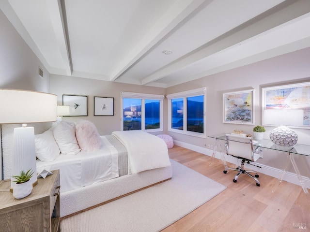 bedroom with beamed ceiling and wood-type flooring