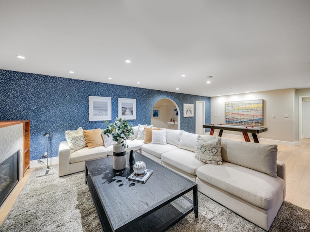 living room with a tiled fireplace and hardwood / wood-style flooring