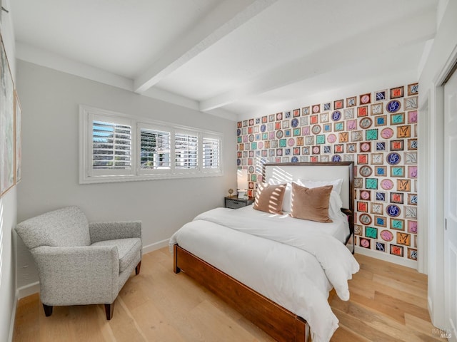 bedroom featuring beamed ceiling and wood-type flooring