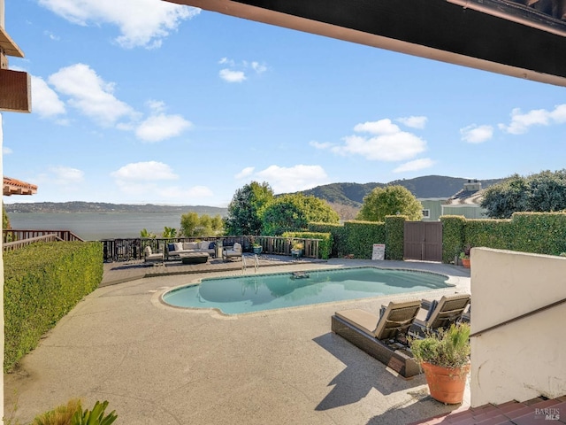 view of pool featuring a water and mountain view and a patio