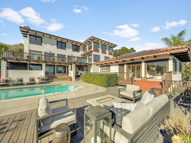 view of pool with a deck and an outdoor fire pit