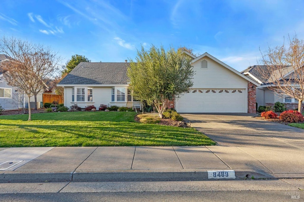 ranch-style home with a garage and a front lawn