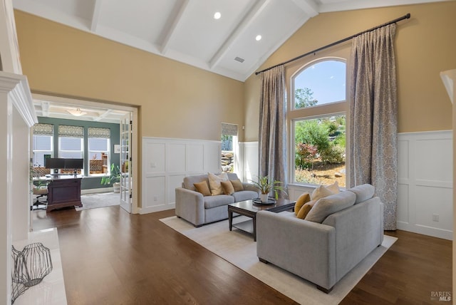 living room featuring beamed ceiling, a healthy amount of sunlight, and hardwood / wood-style flooring