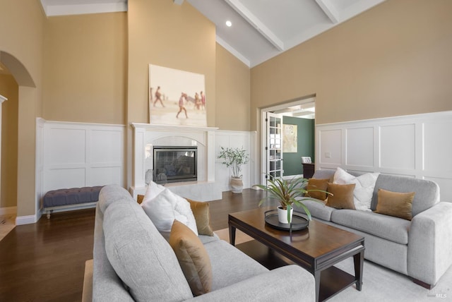 living room with beam ceiling, a fireplace, high vaulted ceiling, and hardwood / wood-style flooring