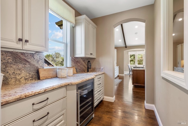 kitchen with white cabinets, tasteful backsplash, beverage cooler, and dark hardwood / wood-style flooring