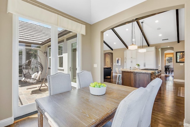 dining room featuring dark hardwood / wood-style flooring and lofted ceiling with beams