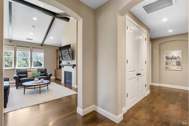 hallway with dark wood-type flooring and beam ceiling