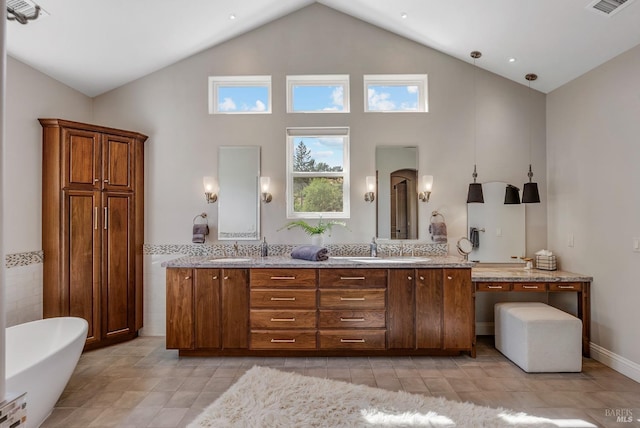 bathroom featuring vanity, a washtub, and high vaulted ceiling