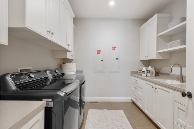 clothes washing area with sink, cabinets, light tile patterned floors, electric panel, and washer and clothes dryer