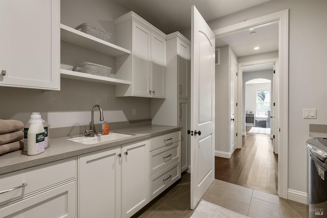 kitchen with white cabinetry, tile patterned floors, and sink