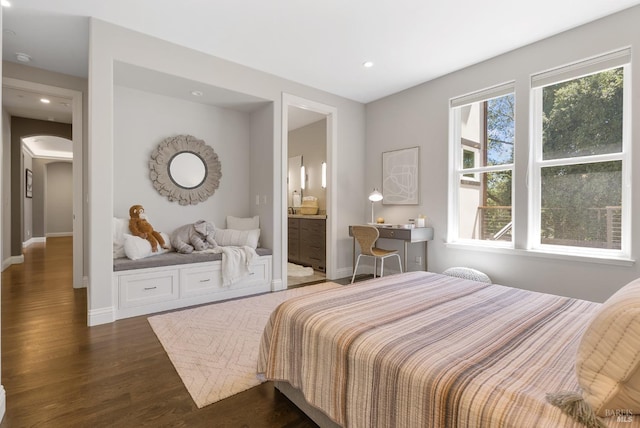 bedroom with dark hardwood / wood-style floors and connected bathroom