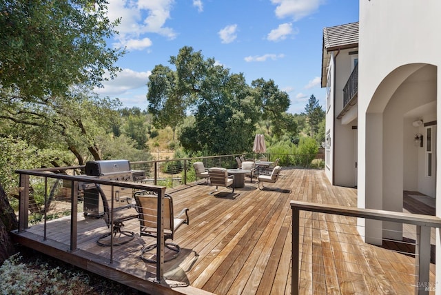 deck with a grill and an outdoor hangout area