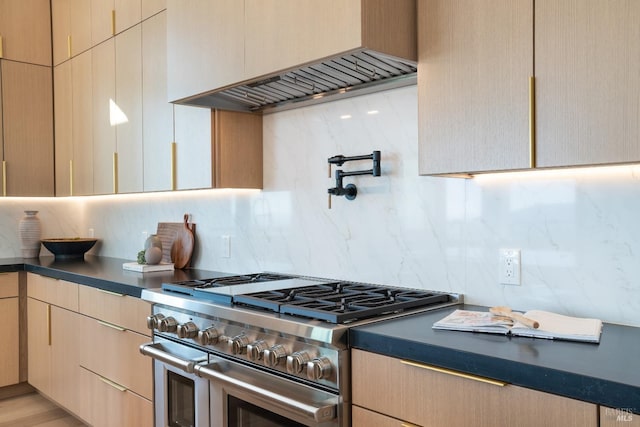 kitchen featuring decorative backsplash, light brown cabinets, double oven range, and premium range hood