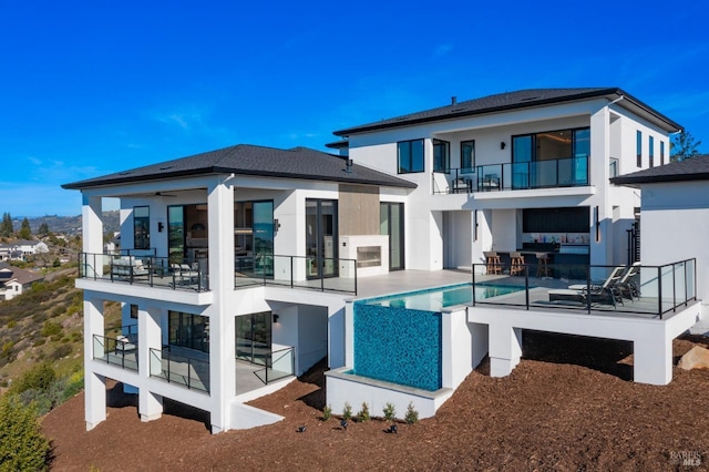 back of property with a balcony and a patio