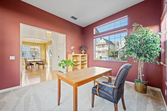 carpeted office with a notable chandelier