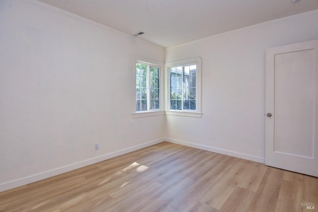 spare room featuring ornamental molding and light hardwood / wood-style flooring