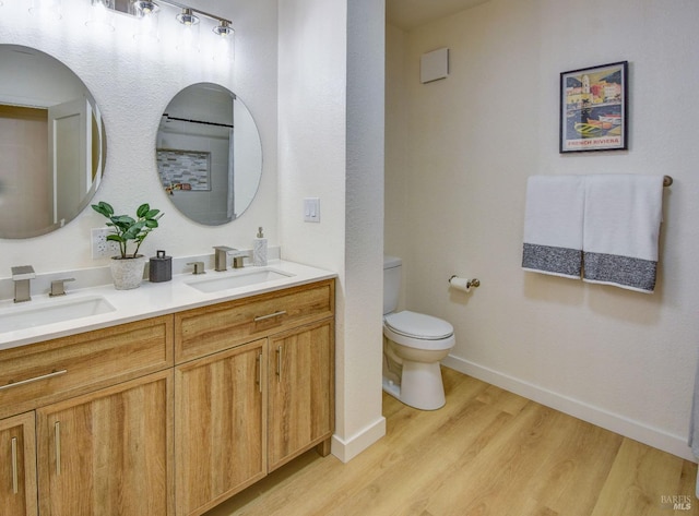 bathroom featuring toilet, wood-type flooring, and vanity