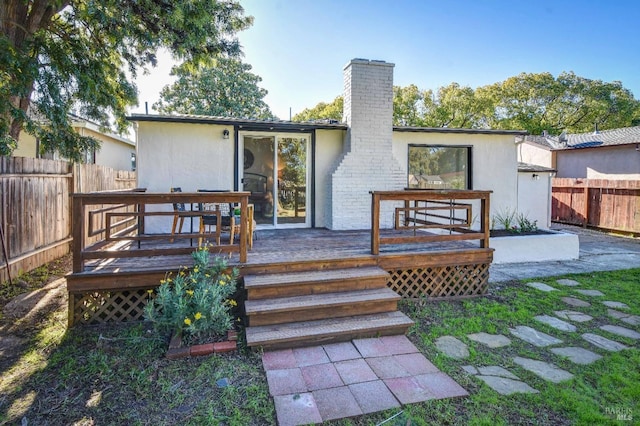 rear view of property featuring a wooden deck