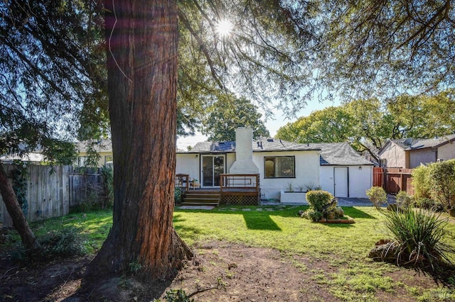 back of house with a wooden deck and a yard