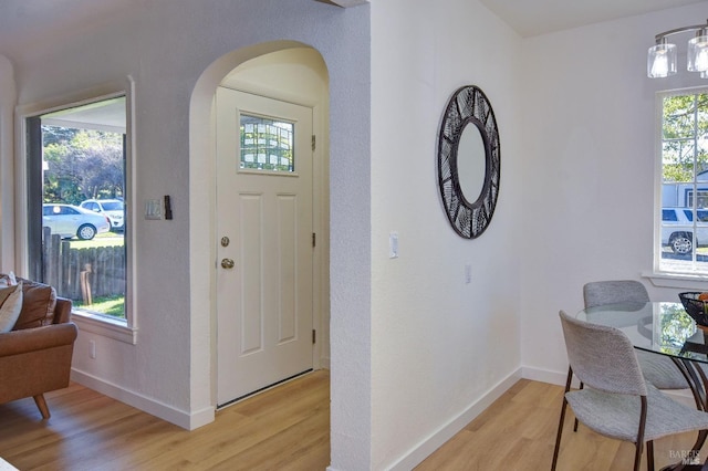 foyer entrance with a chandelier and light hardwood / wood-style flooring