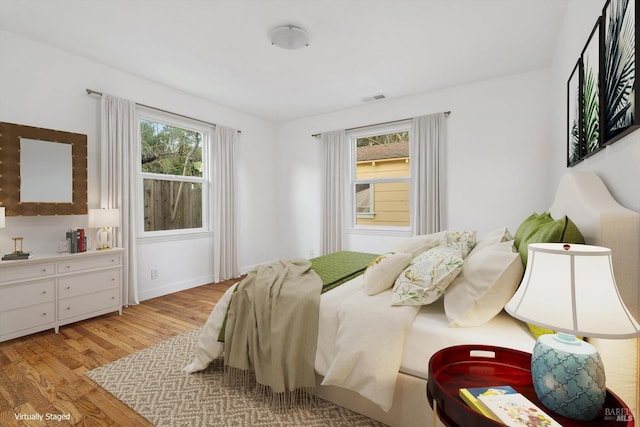 bedroom with light wood-type flooring and multiple windows