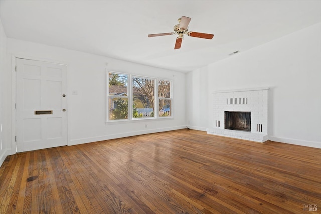 unfurnished living room featuring ceiling fan, hardwood / wood-style floors, and a brick fireplace