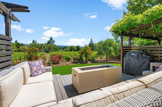 wooden deck featuring an outdoor living space with a fire pit, fence, and area for grilling
