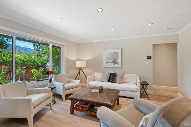 living area with crown molding, recessed lighting, baseboards, and light wood-style floors